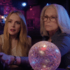 Anna and Tess sitting with a crystal ball, having their fortune told.